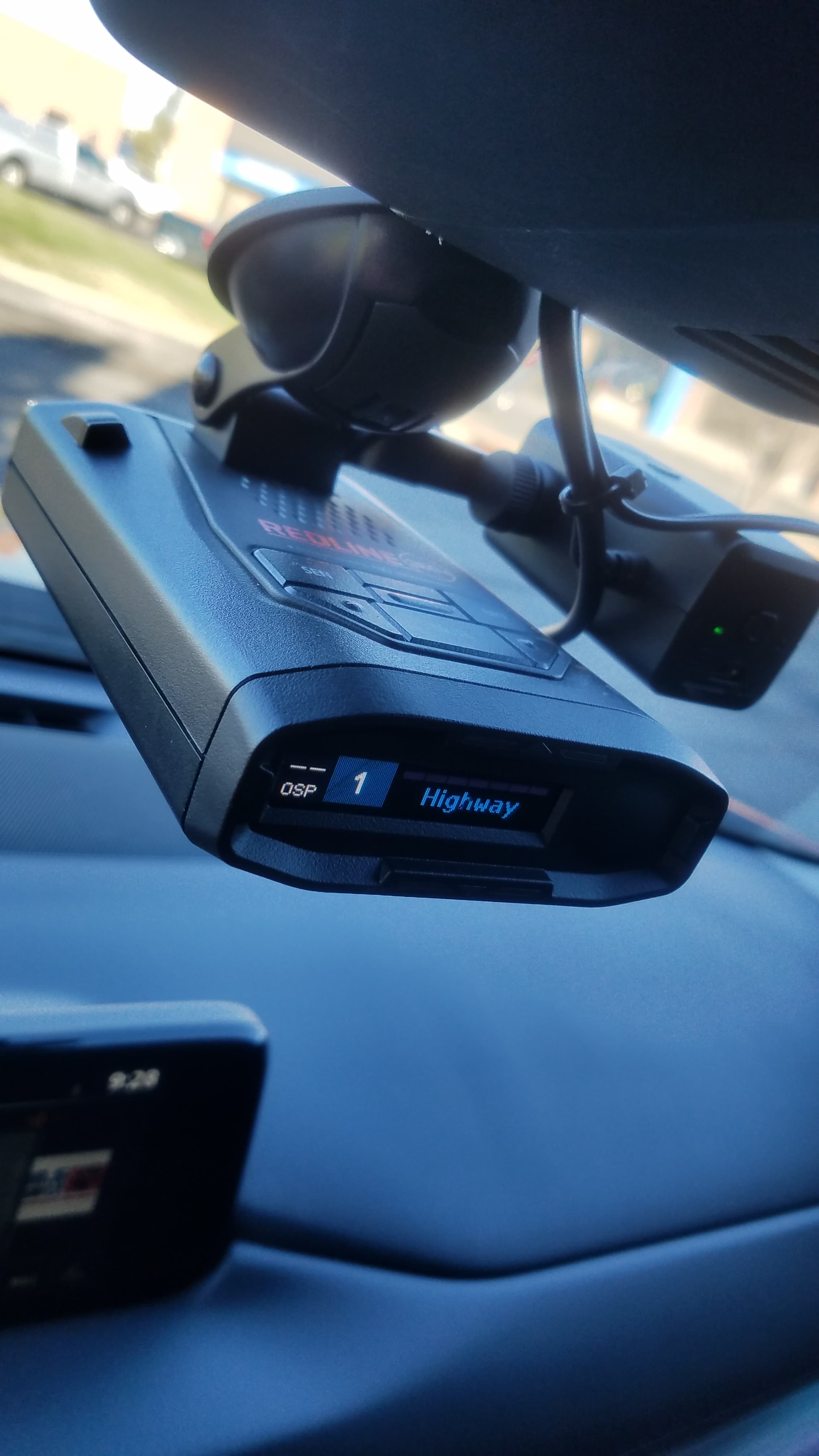 Escort radar detector hardwired and mounted below the rearview mirror.