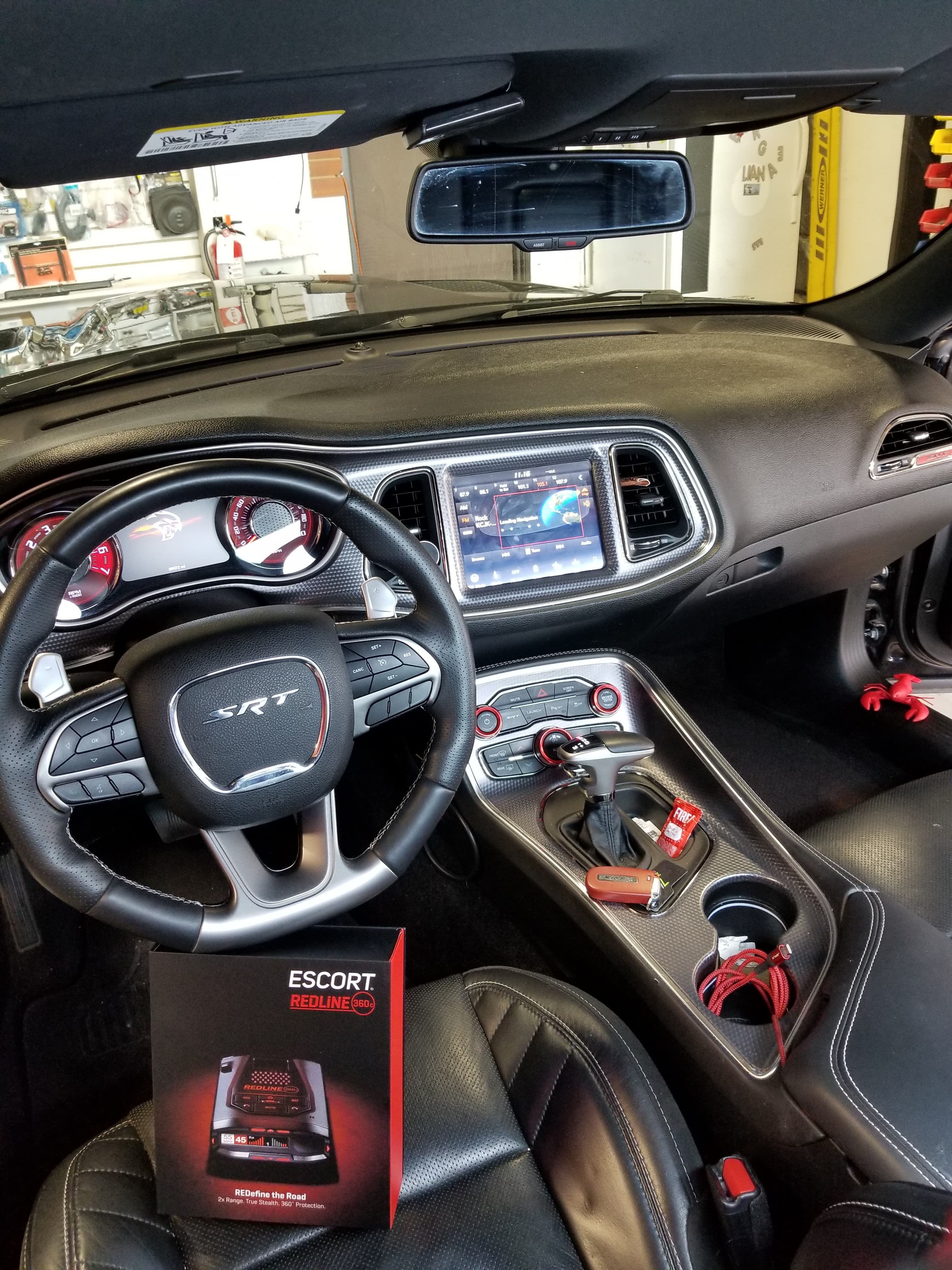 Escort Redline radar detector boxed and staged on a customer vehicle seat.